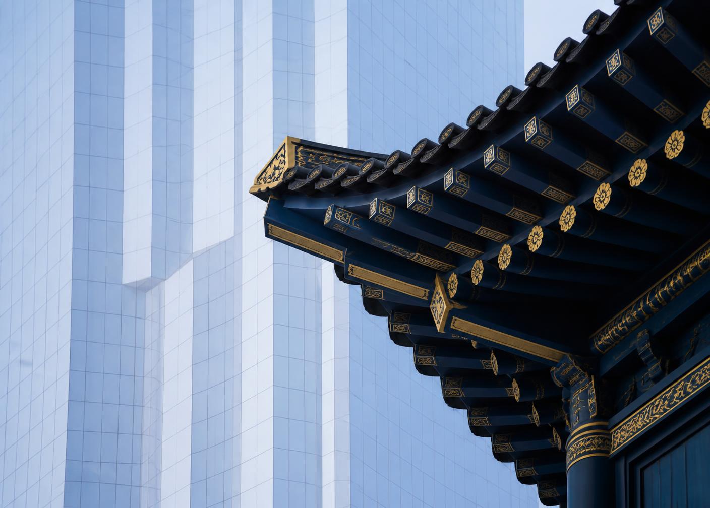 Traditional Korean eaves against a modern glass tower
